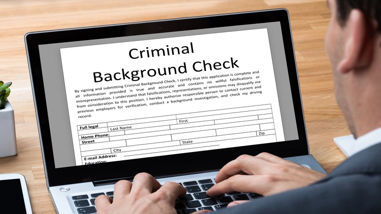 Image showing a person filling out an online criminal background check form on their computer.