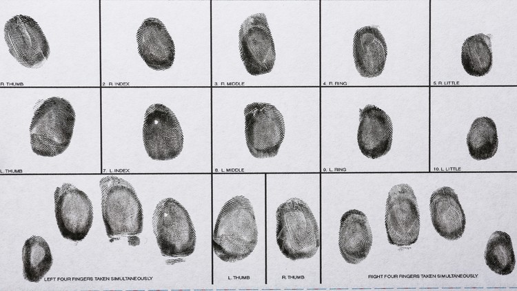 Closeup image of a fingerprint card showing a grid of fingerprint patterns, labelled with the corresponding finger name and position.