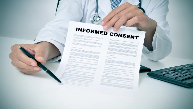 Image showing a healthcare professional holding an informed consent document for a background check.
