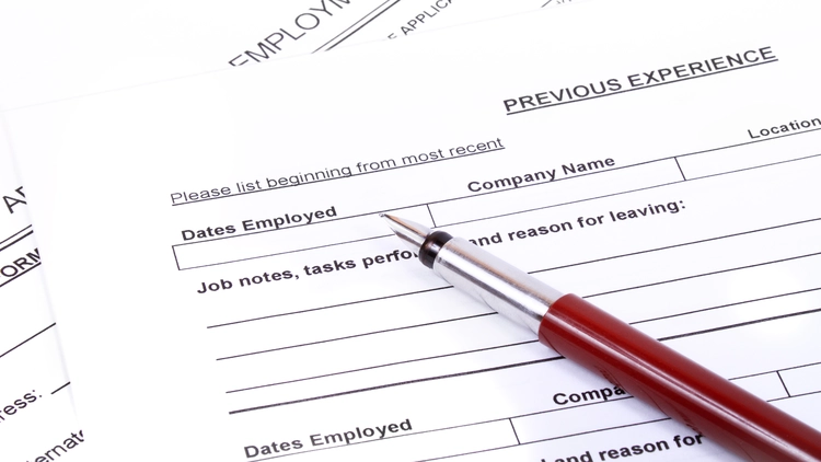 An image of a job application form previous experience section with a red pen placed on the form.