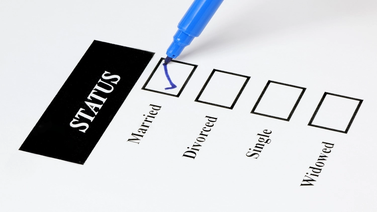 An image showing a checklist with the word 'Status' at the top, and several checkboxes below labeled 'Married', 'Divorced', 'Single', and 'Widowed', with a blue pen pointing to the checkboxes.