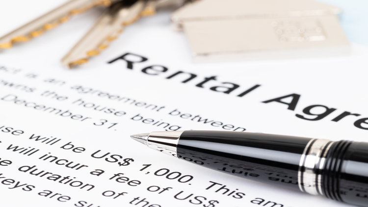 An image showing a rental agreement document with a pen placed on top of it.
