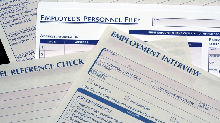 An image showing several documents related to employee personnel files and employment processes.