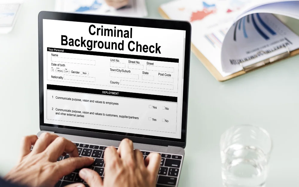 Man filling out a criminal background check on a laptop. 