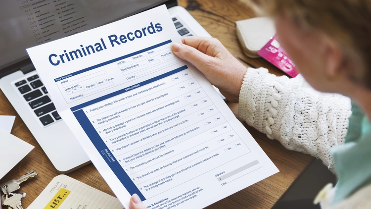 A person holding a criminal records form.