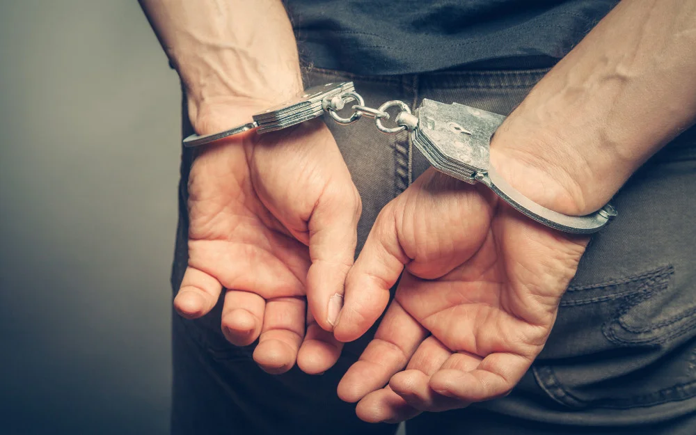Man's hands in handcuffs behind his back. 
