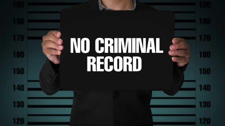 A man holding a blackboard bearing the words 'no criminal record.'