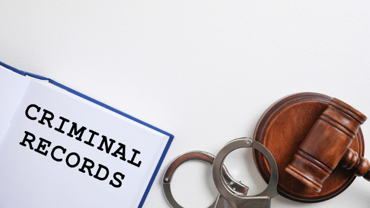 Top view of a criminal record book, handcuffs, and a gavel on a white background.