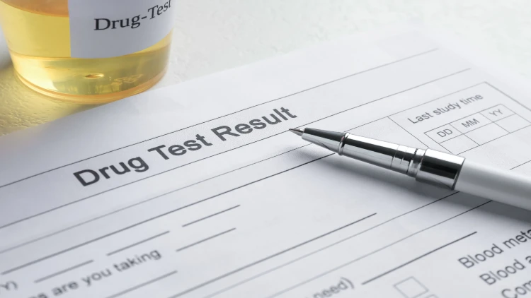 Close-up of drug test result form and sample with pen on top.