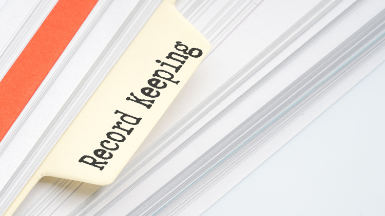 Close up view of bundle of documents tagged with Record Keeping.