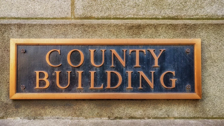 Close-up view of the exterior sign of a county building.