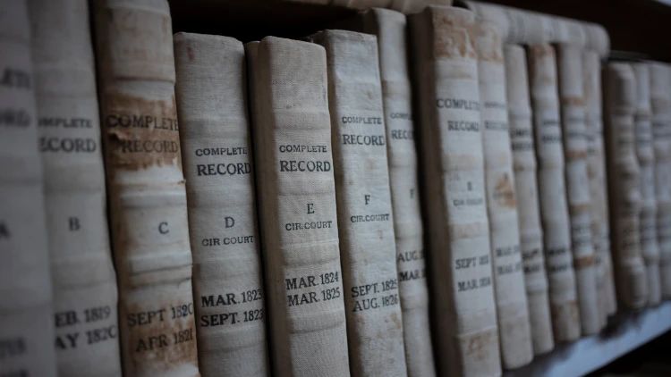 Close-up view of a stack of public records books neatly arranged on a bookshelf.