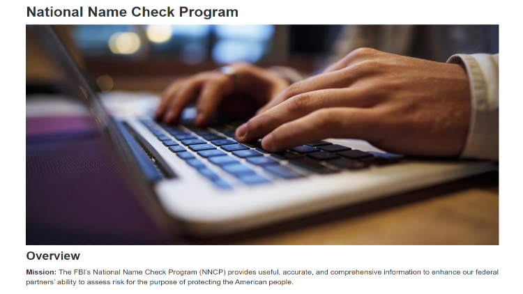 National name check program screenshot operated by the FBI with a close up of a man's hands typing into a laptop keyboard to run a name based background check. 