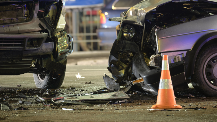 A closeup of 2 cars caught in a traffic accident with broken bumpers.