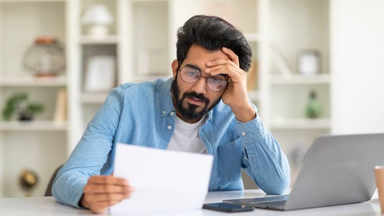 An image showing a person looking stressed while holding a background check report.