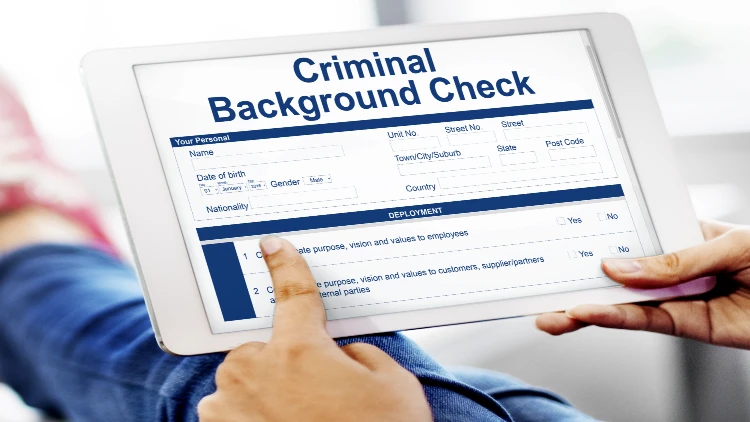 close up image of a hand pointing at a criminal background check form on a tablet