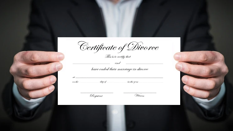 Close up image of two hands holding a certificate of divorce