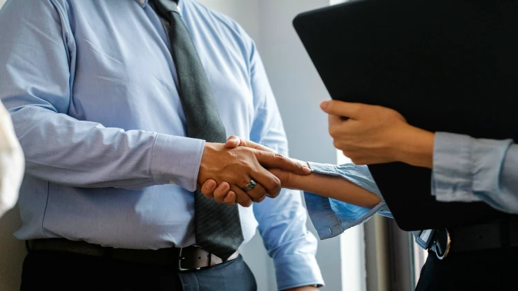 Close up image of an employer and employee shaking hands showing agreement with no discrimination