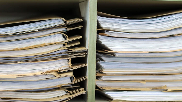 Close up image of stacked public records on a shelf