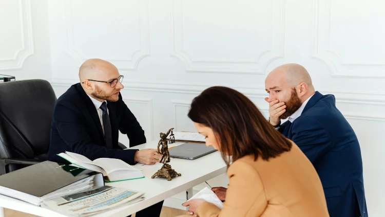 Image of a couple talking to a lawyer to file or discuss divorce