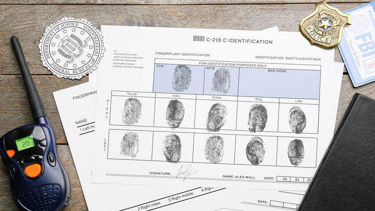 An image showing a fingerprint identification form, police badge, and other items associated with criminal background checks.