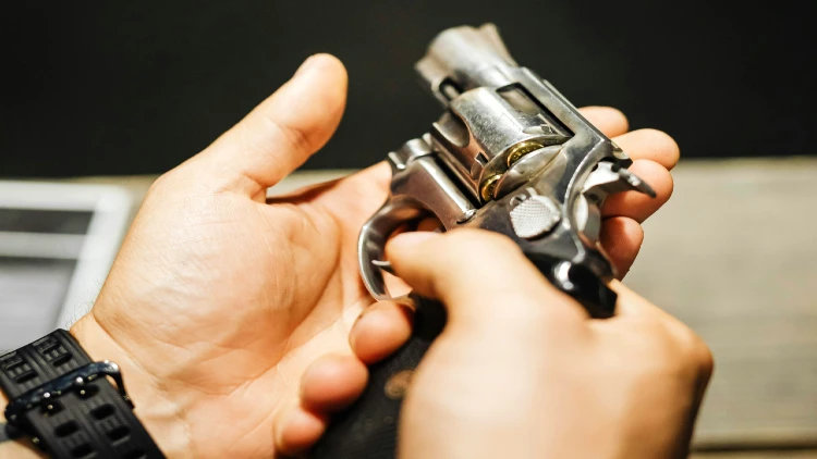 Close up image of a gun being held with two hands