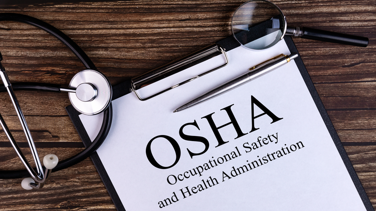 A clipboard with the OSHA (Occupational Safety and Health Administration) on it, surrounded by medical equipment.