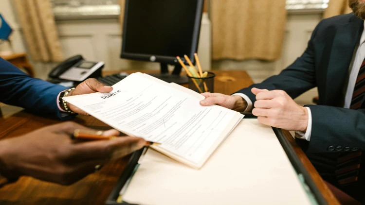 Image of two people holding and discussing a divorce paper
