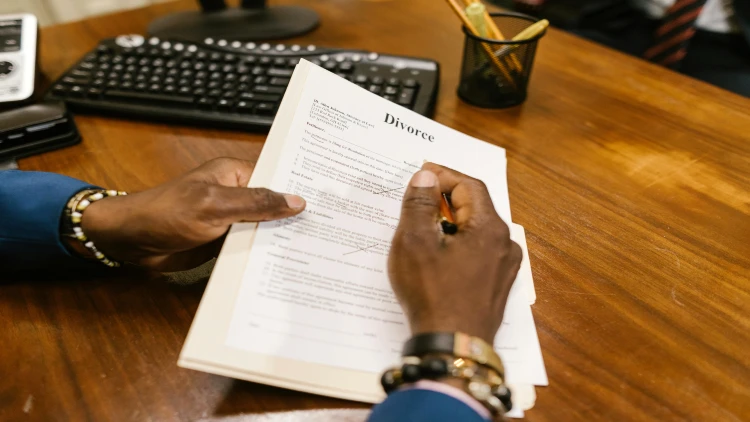 Image of a person holding and signing a divorce paper