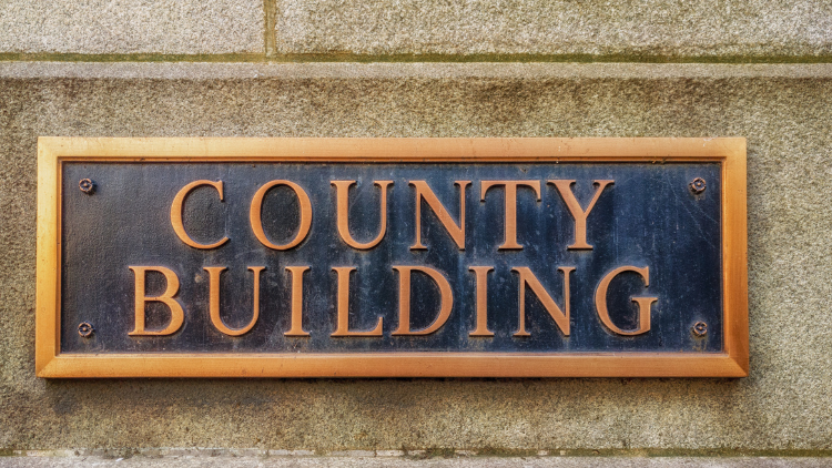 Close-up view of the exterior sign of a county building.