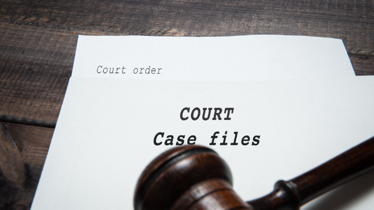 A stack of old court documents with a gavel on top.