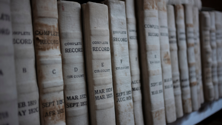Close-up view of a stack of public records books neatly arranged on a bookshelf.
