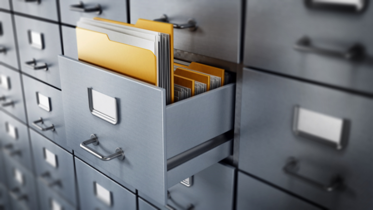 Image of a metal records filing cabinet with one door opened, revealing yellow folders filled with documents.