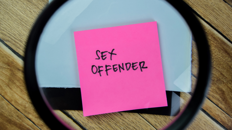 Pink sticky note with the words 'sex offender' written on it under a magnifying glass.
